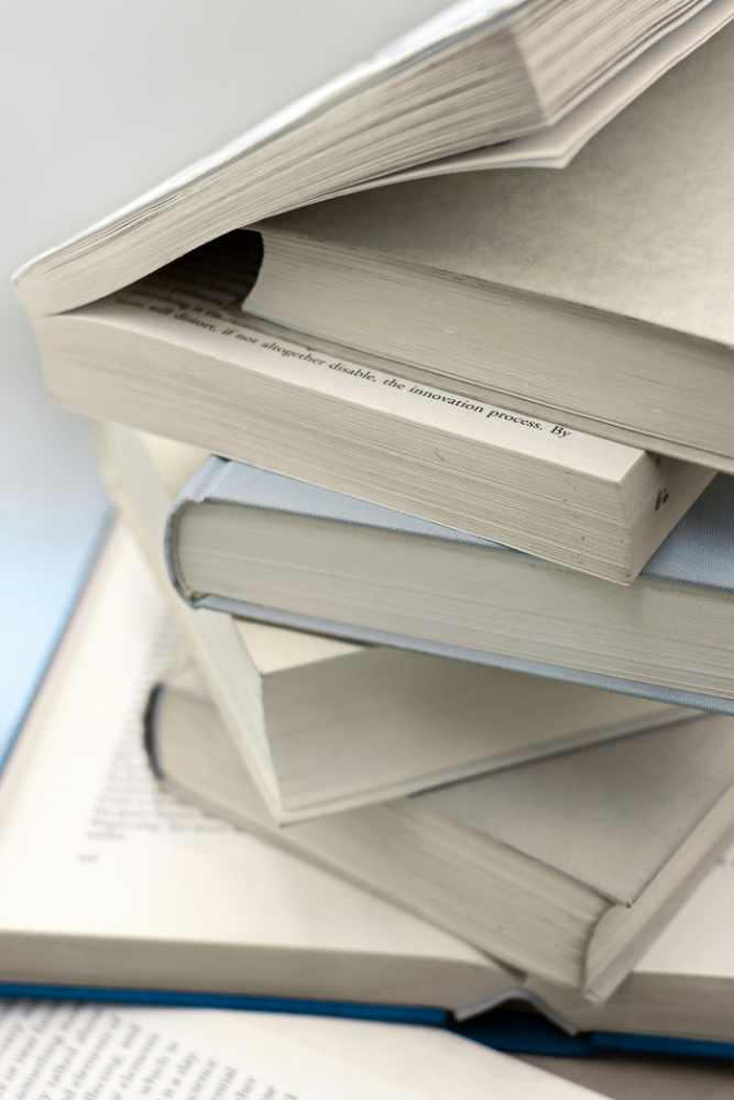 Stack of books with purple covers symbolising professional editing, indexing, and technical writing services by accredited editor DZ Editing in Melbourne.